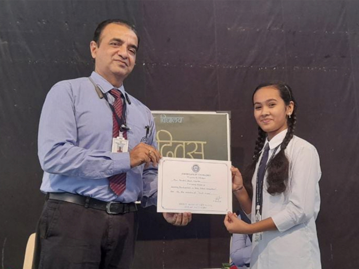 Students receiving certificates on Hindi Diwas at Mukul Madhav Vidyalaya